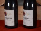 two bottles of wine sitting on a table next to each other