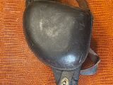 un sac à main noir avec une poignée en cuir sur un fond orange