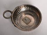 an antique silver plate with a handle on a white surface