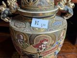 a large vase with a lid sitting on a wooden table