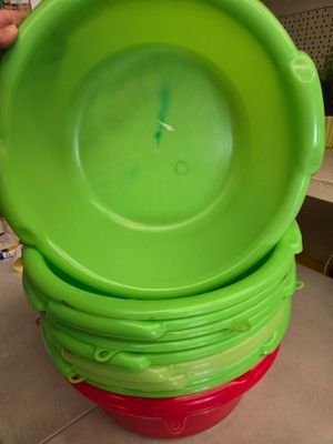plusieurs bols en plastique verts et rouges empilés les uns sur les autres