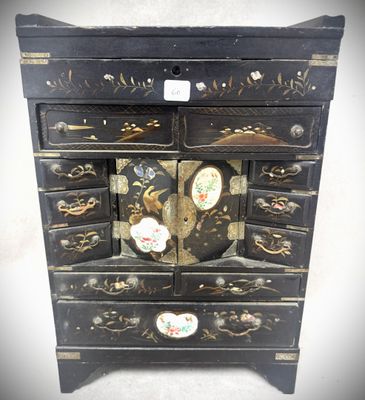 une commode noire ornée d'un motif d'oiseau