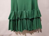 a green skirt with ruffles hanging on a hanger