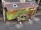 a green dumpster sitting on the side of the road