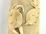 a small vase that has a picture of a goat on it