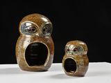 two ceramic owl figurines sitting on top of a white table