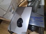 a person standing next to a laptop with a mouse on top of it