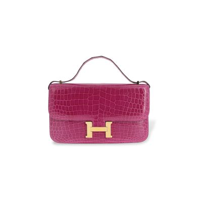 un sac à main rose avec un « H » doré sur la poignée