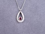 a silver necklace with a red stone in the center