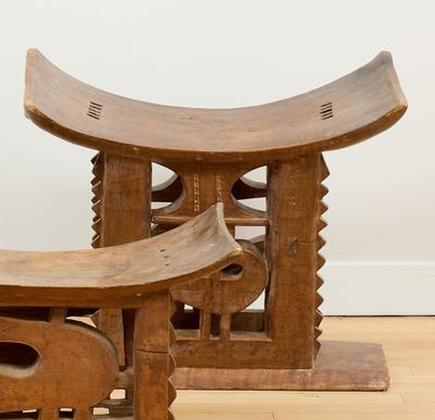 deux tabourets en bois placés l'un à côté de l'autre sur un parquet en bois dur