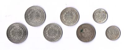 six types différents de pièces d'argent sur une surface blanche