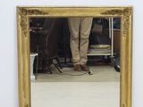 un homme debout devant un miroir dans une pièce