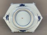 a close up of a blue and white plate with insects on it