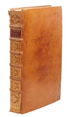 un vieux livre à la couverture brune posé sur une surface blanche