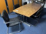 a wooden table with black chairs around it in a room