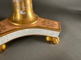 a gold and white vase sitting on top of a table