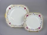 two white plates with gold rims and floral designs on them