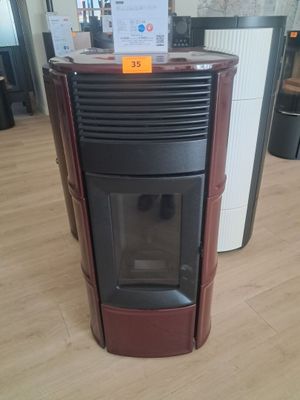 un poêle noir et rouge dans une pièce avec du parquet