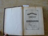 Quelqu'un tient un livre ouvert sur une table sur laquelle est posée une étiquette.