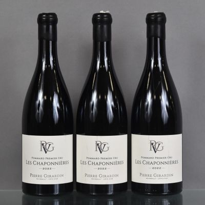 three bottles of wine are lined up on a table