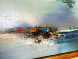 une photo d'un tableau représentant une scène de plage accroché au mur