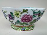 un bol blanc orné de fleurs violettes et de feuilles vertes