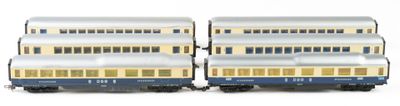 two blue and white train cars sitting next to each other on a white surface