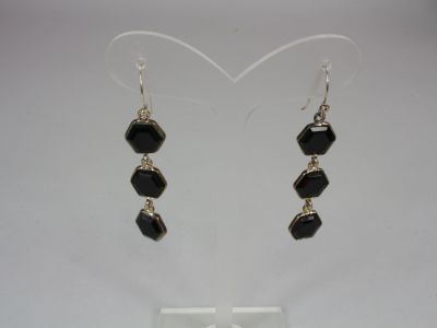 a pair of black and silver earrings on a white background