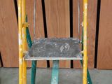 un tabouret jaune et vert posé sur un sol vert