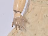 a doll that is wearing a dress and gloves