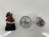 trois figurines miniatures posées sur une surface blanche