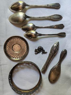 beaucoup de cuillères en argent et d'autres objets en argent sur une table