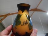 une main tenant un vase orné d'un motif