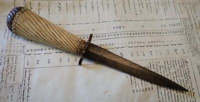 un couteau posé sur une feuille de papier