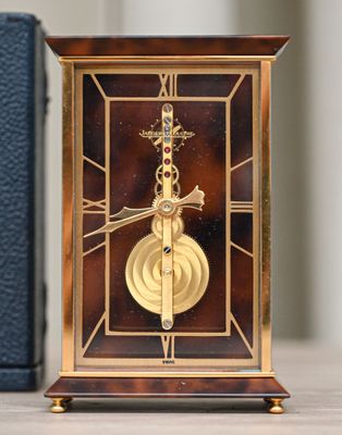 a clock that is sitting on a table next to a book