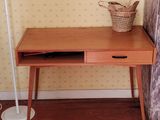 a small desk with a lamp on top of it