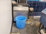 a blue bucket sitting on the floor of a kitchen