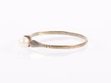 a close up of a gold ring with a pearl on it