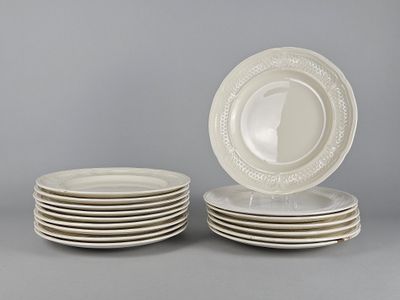 plusieurs assiettes blanches empilées les unes sur les autres sur une surface grise