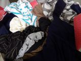 a pile of clothes that is sitting on a bed