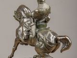 bronze statue of a man on a horse with a bird on its back