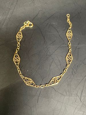 a close up of a gold bracelet on a black surface
