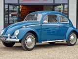 une Coccinelle VW bleue garée devant un immeuble
