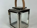une lanterne en verre avec une poignée en cuir sur fond blanc