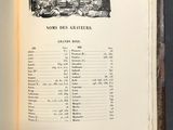 un livre ouvert sur lequel figure une image en noir et blanc représentant un groupe de personnes assises à une table