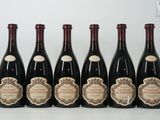 six bouteilles de vin sont alignées sur une table