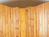 a toilet in a bathroom with a wooden paneled wall behind it
