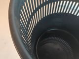 a black plastic basket that is on a table
