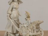 statue of a woman and a child with a cart of sheep