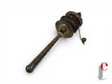 a small metal object with a long handle on a white surface